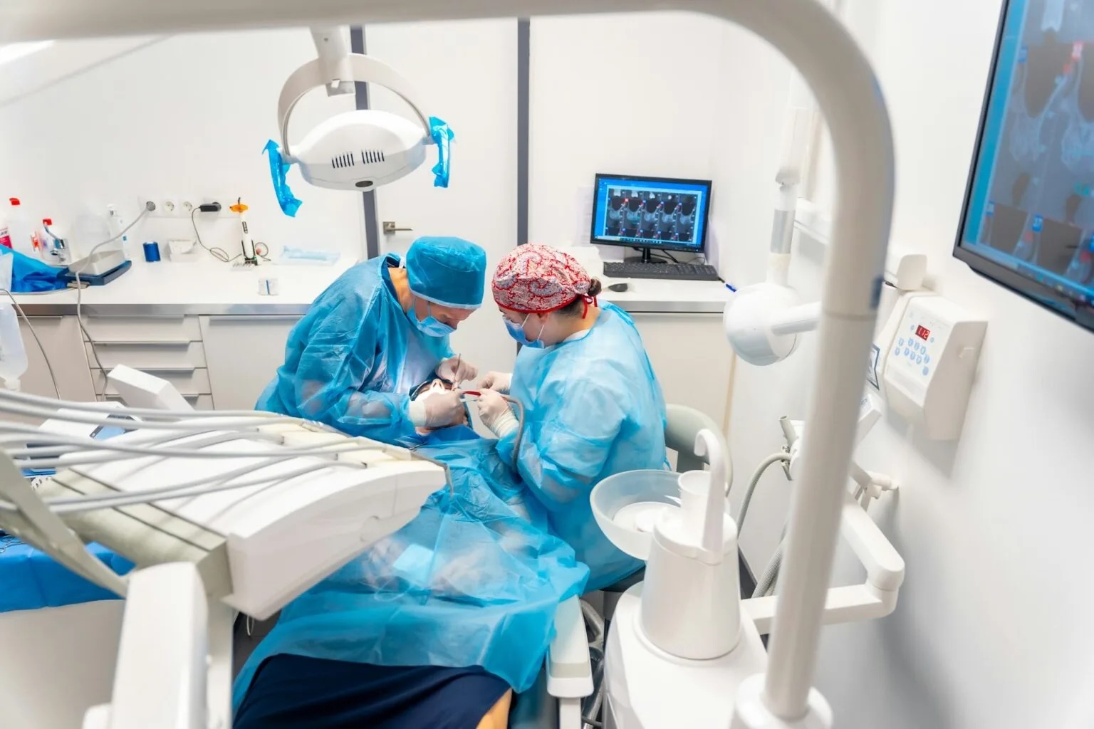 Oralchirurg und Assistenz während einer Implantatoperation