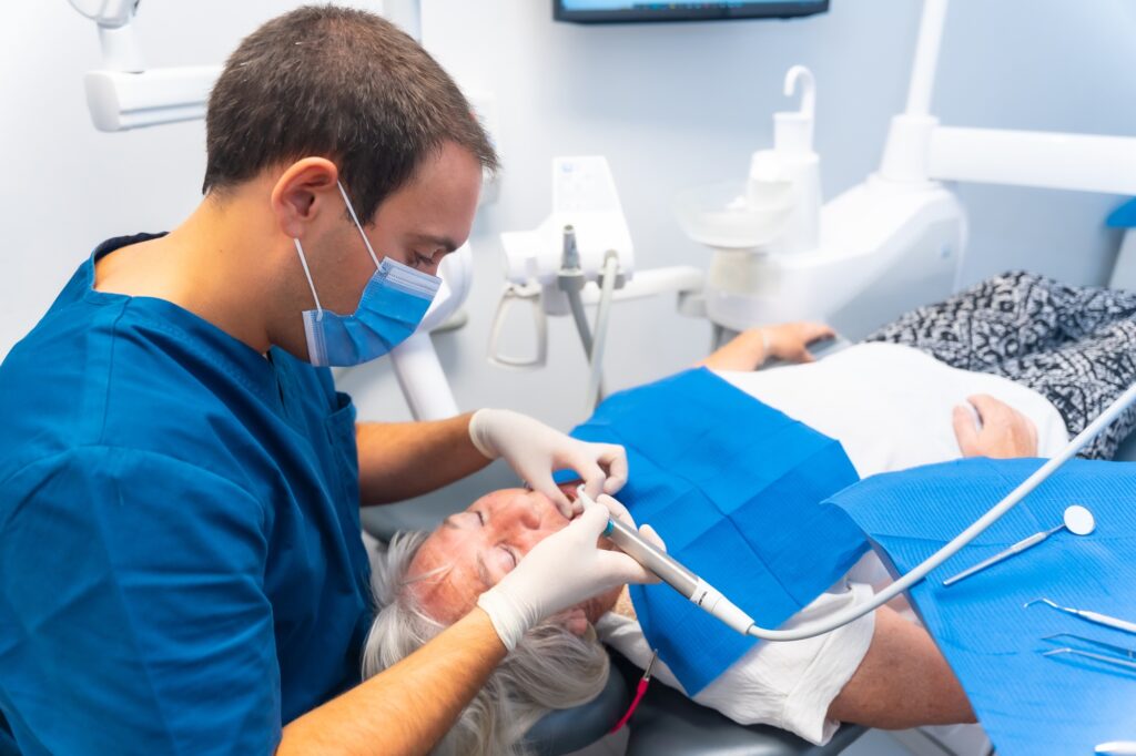 Dental clinic, elderly woman at dentist checking implants with dentist doctor, face mask
