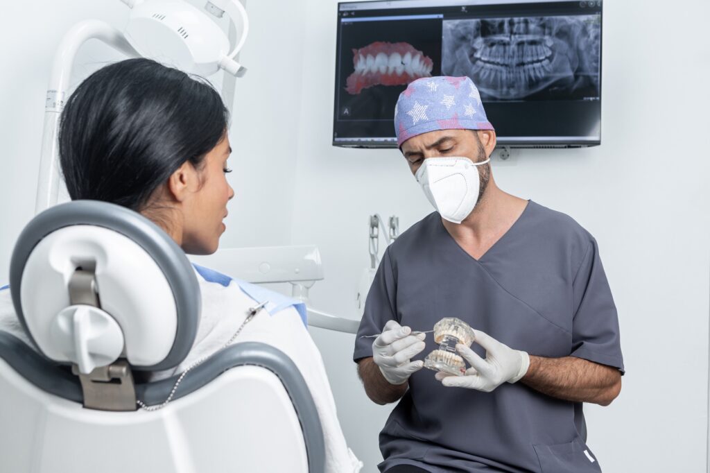Dentist explaining to a patient how a dental mould works in a dental clinic