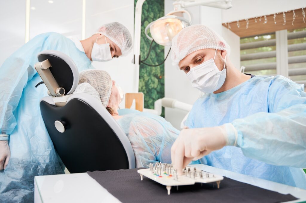 Male dentist using dental implant kit in dental office.