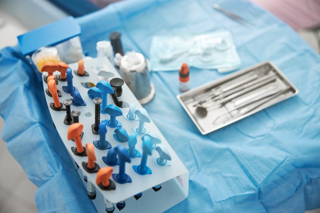 Table with dental composite resins stand near instrument tray